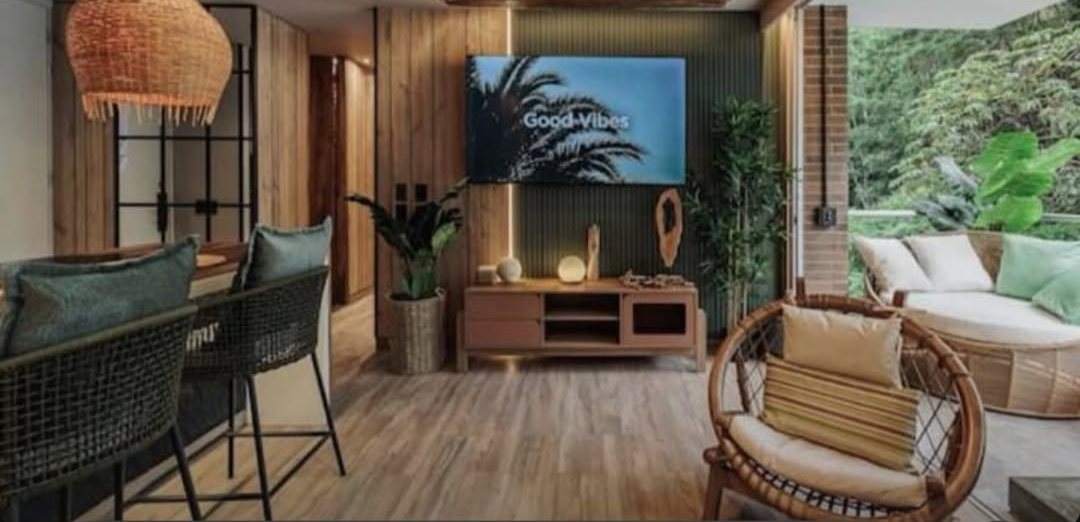 Sala con muebles en fibra natural y balcón con vegetación