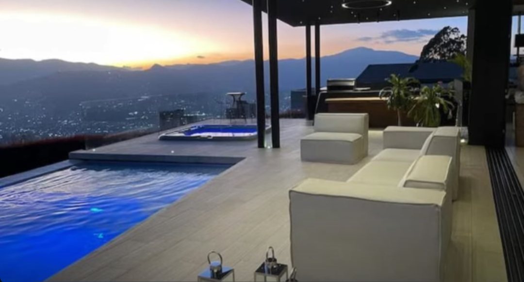Terraza con piscina y vista a Medellín al atardecer